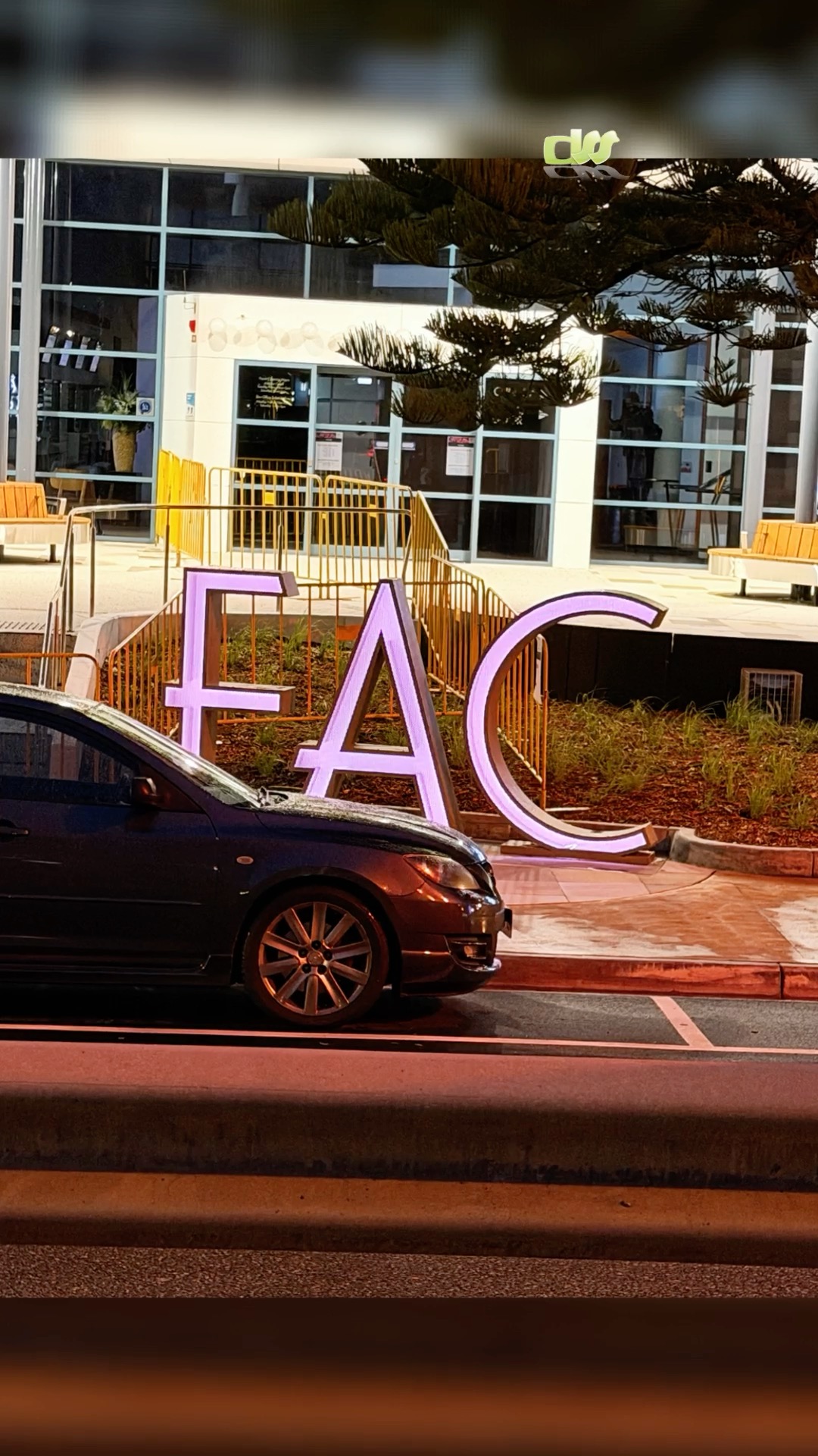 Large illuminated lettering beside a vehicle